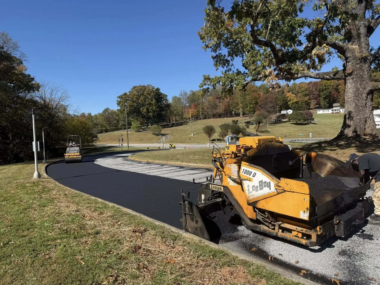 Asphalt paver at work on a curved residential driveway