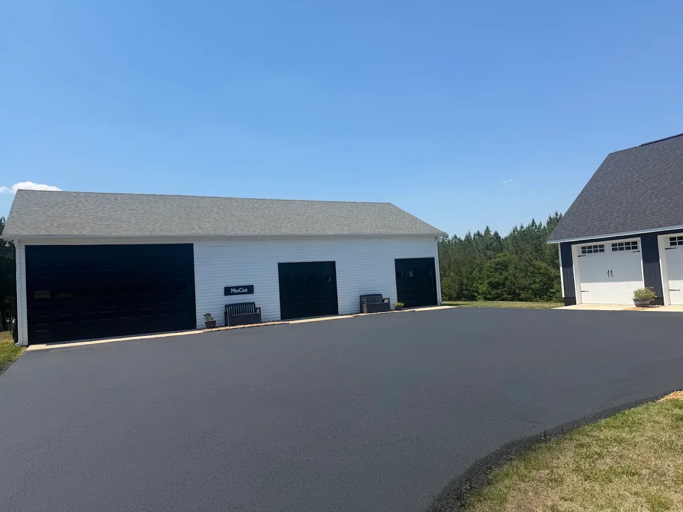 Even dark asphalt finish across a courtyard between two detached garages