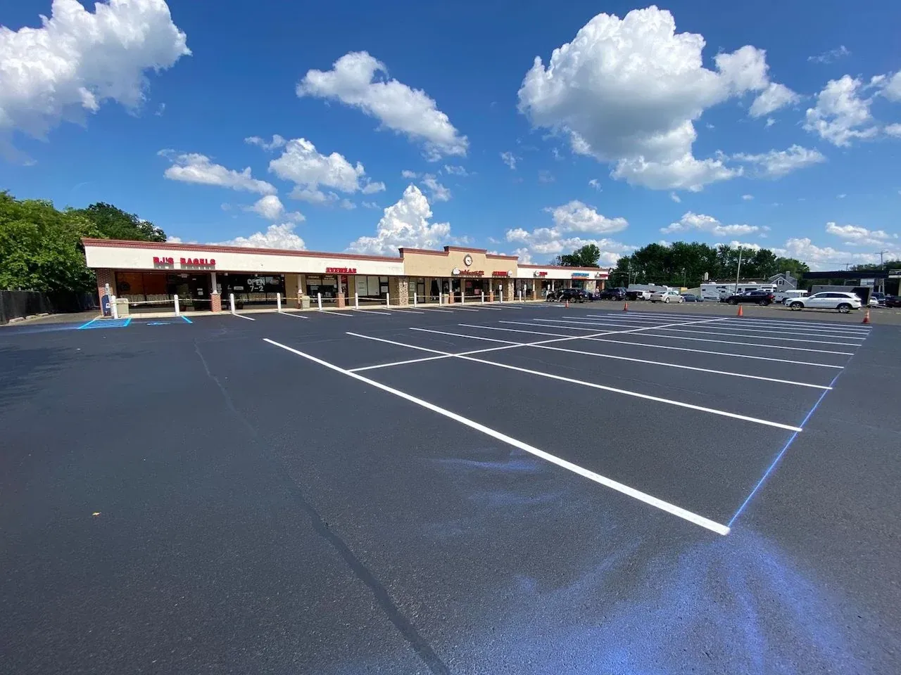 Fresh white parking bay lines across a retail parking lot