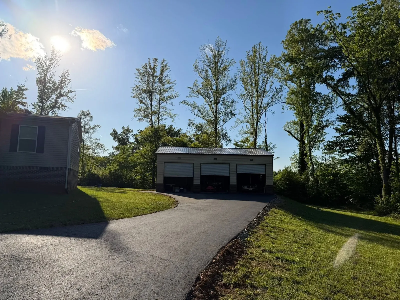 New asphalt driveway leading to the same detached three-car garage